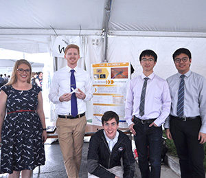 Five students -- membes of Team Fat Thunder - stand in front of their poster