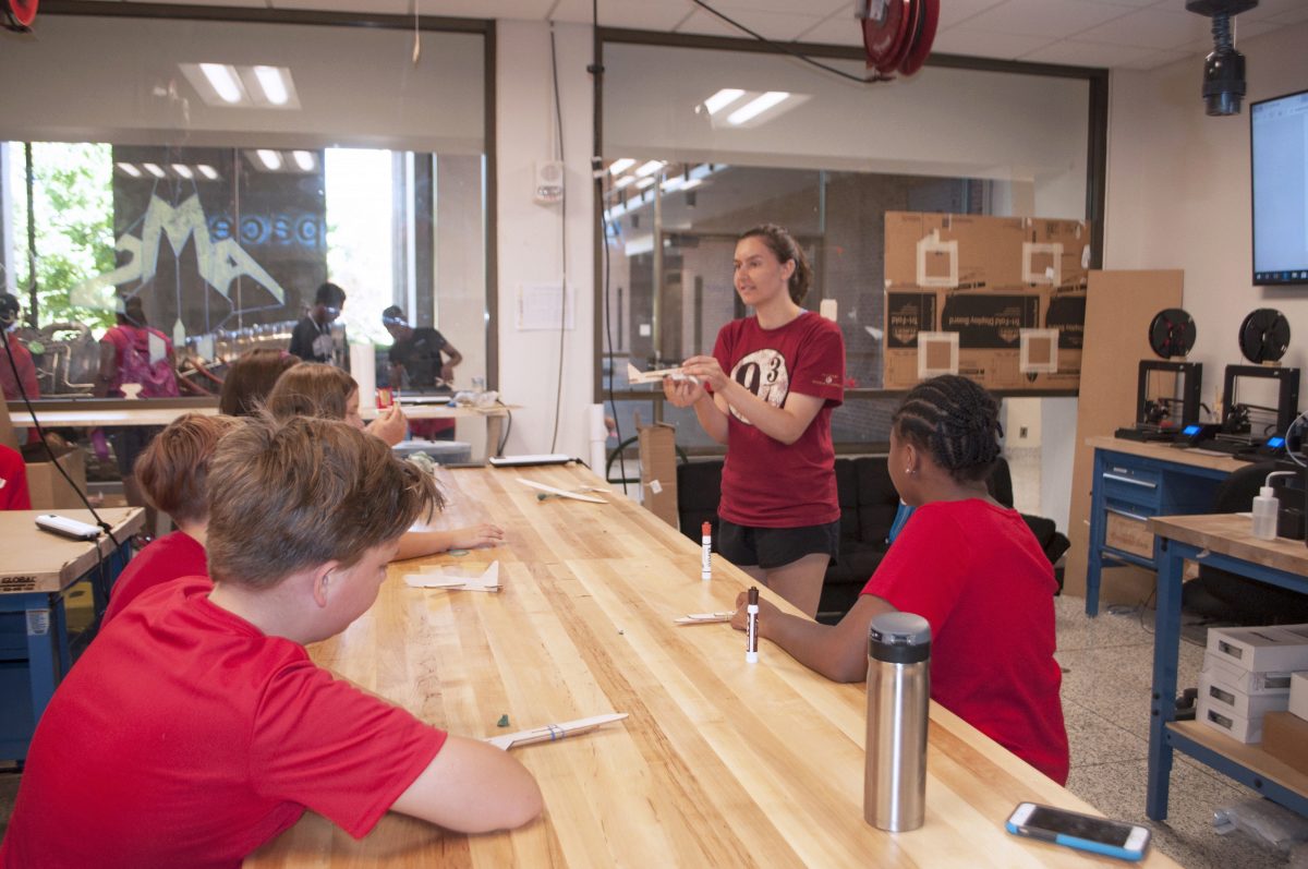 Julia Filloon instructs the students on how to make a balsa glider