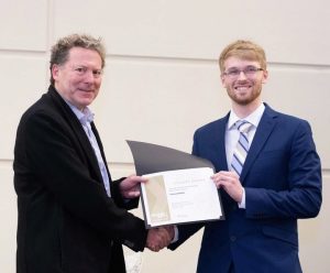 Cason Butler receiving his award from Assoc. Dean Larry Jacobs