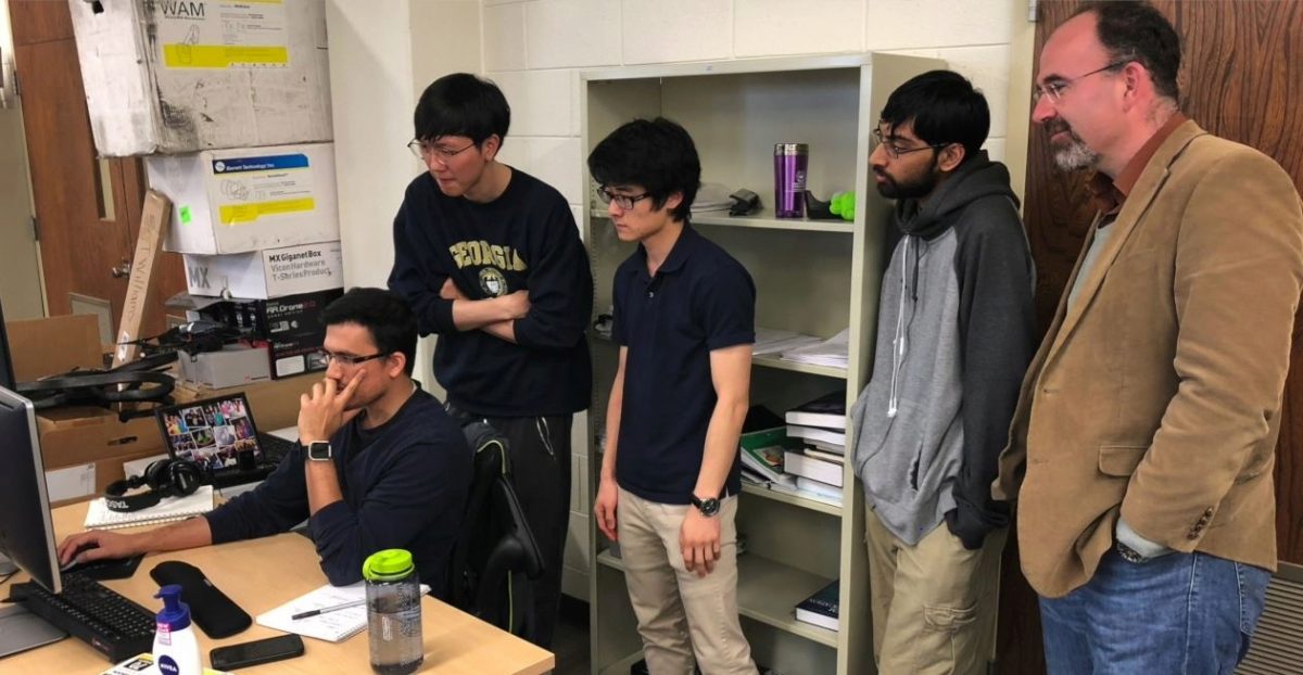 Theodorou, Patel, Oshin, Gandi checking out some calculations on a computer screen