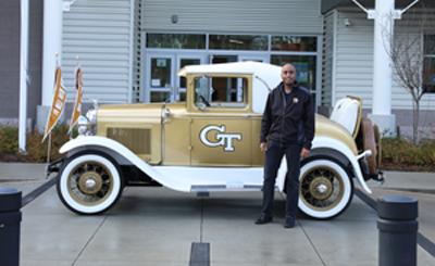 Dr. Stephen Ruffin poses outside of the Tuskegee Airmen Global Academy with the Ramblin' Wreck